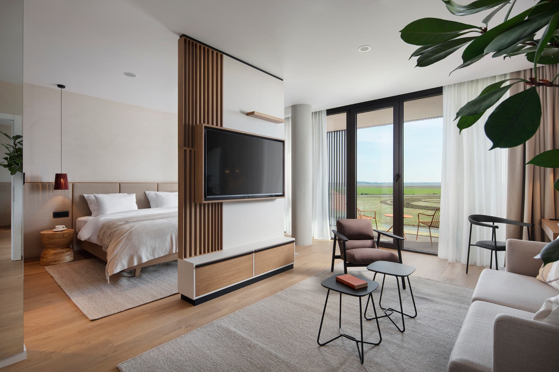 Hotellsvit med säng, fåtölj och soffgrupp